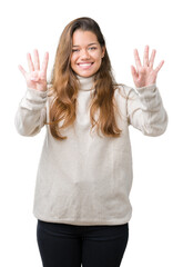 Fototapeta na wymiar Young beautiful brunette woman wearing turtleneck sweater over isolated background showing and pointing up with fingers number nine while smiling confident and happy.