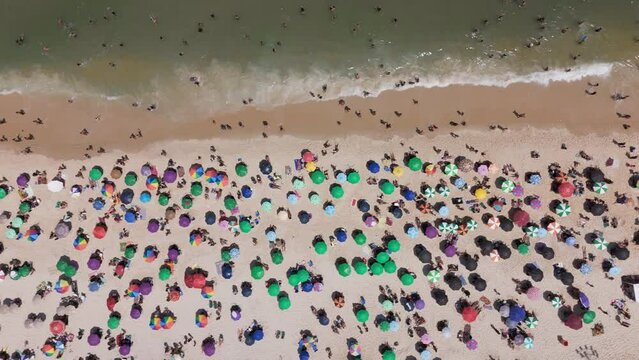 Aerial top down view of people enjoying the sun on sunny beach in Rio de Janeiro
