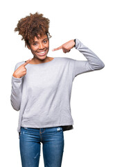 Beautiful young african american woman over isolated background smiling confident showing and pointing with fingers teeth and mouth. Health concept.