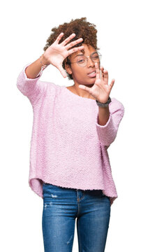 Beautiful young african american woman wearing glasses over isolated background Smiling doing frame using hands palms and fingers, camera perspective