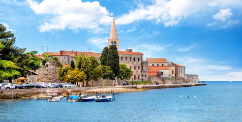 Amazing view of old Assumption of Mary church with sea and boats in foreground. Cityscape of Porec,...