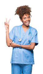 Young african american doctor woman over isolated background smiling with happy face winking at the...