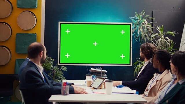 Promotions manager and team members watching a video on mockup screen, analyzing PR and digital marketing ad campaign. Firm employees reviewing sales strategy in a fruitful meeting. Camera B.