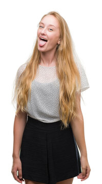 Blonde teenager woman wearing moles shirt sticking tongue out happy with funny expression. Emotion concept.