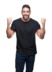 Fototapeta premium Young handsome man over isolated background celebrating surprised and amazed for success with arms raised and open eyes. Winner concept.