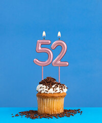 Birthday candle with cupcake on blue background - Number 52