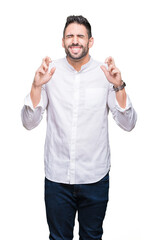 Fototapeta premium Young business man over isolated background smiling crossing fingers with hope and eyes closed. Luck and superstitious concept.