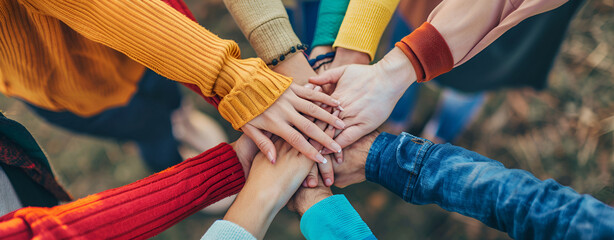 Low angle shot of group of women making a stack of hands in a huddle symbolizing teamwork, friendship, and unity. - obrazy, fototapety, plakaty