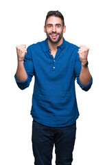 Fototapeta premium Young handsome man over isolated background celebrating surprised and amazed for success with arms raised and open eyes. Winner concept.