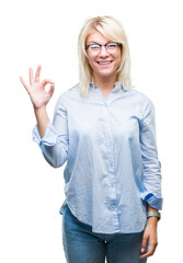 Young beautiful blonde business woman wearing glasses over isolated background smiling positive doing ok sign with hand and fingers. Successful expression.