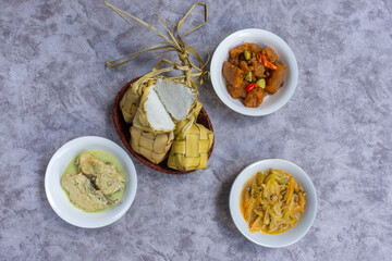 Ketupat Lebaran, served with opor ayam, sambal goreng krecek and sayur labu siam. Traditional celebratory dishes during Eid al-Fitr in Indonesia.