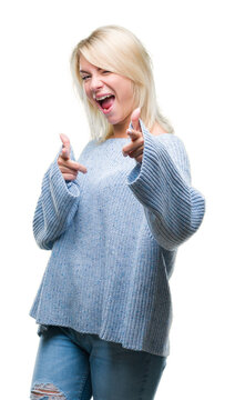 Young beautiful blonde woman wearing winter sweater over isolated background pointing fingers to camera with happy and funny face. Good energy and vibes.