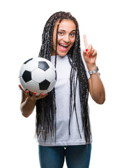 Young braided hair african american girl holding soccer ball over isolated background surprised...