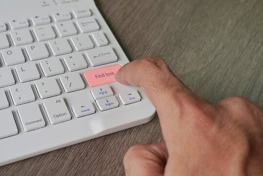 Finger pressing computer keyboard with text FIND LOVE. Online dating concept