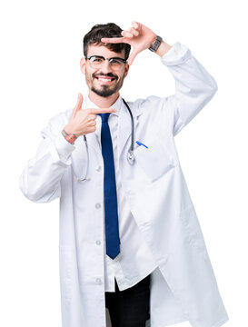 Young doctor man wearing hospital coat over isolated background smiling making frame with hands and fingers with happy face. Creativity and photography concept.