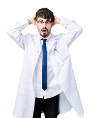 Young professional scientist man wearing white coat over isolated background Crazy and scared with hands on head, afraid and surprised of shock with open mouth