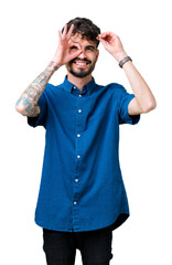 Young handsome man wearing glasses over isolated background doing ok gesture with hand smiling, eye looking through fingers with happy face.