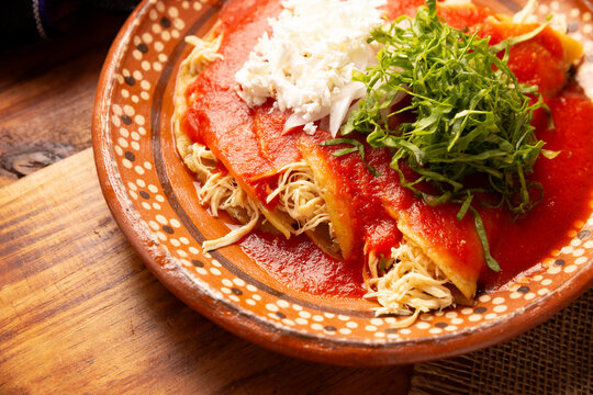 Entomatadas. Also known as Enjitomatadas, a typical dish of Mexican cuisine prepared with corn tortilla, tomato sauce and stuffed with shredded chicken meat. Classic homemade recipe.