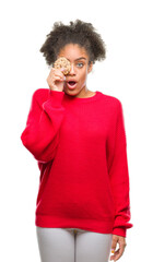 Fototapeta na wymiar Young afro american woman eating chocolate cookie over isolated background scared in shock with a surprise face, afraid and excited with fear expression