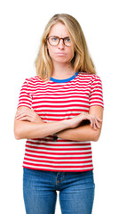 Beautiful young woman wearing glasses over isolated background skeptic and nervous, disapproving...