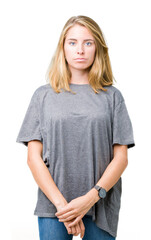 Fototapeta premium Beautiful young woman wearing oversize casual t-shirt over isolated background Relaxed with serious expression on face. Simple and natural looking at the camera.