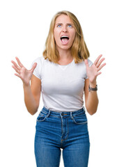 Beautiful young woman wearing casual white t-shirt over isolated background crazy and mad shouting and yelling with aggressive expression and arms raised. Frustration concept.