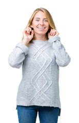 Beautiful young woman wearing winter sweater over isolated background covering ears with fingers with annoyed expression for the noise of loud music. Deaf concept.