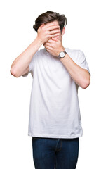 Fototapeta premium Young handsome man wearing casual white t-shirt over isolated background Covering eyes and mouth with hands, surprised and shocked. Hiding emotion