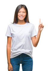 Young asian woman over isolated background showing and pointing up with finger number one while smiling confident and happy.