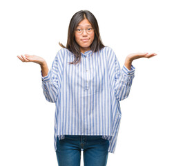 Young asian woman over isolated background clueless and confused expression with arms and hands...