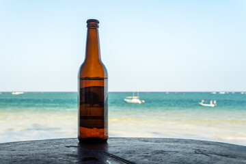 Bottle of beer on beach, copy space