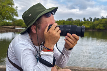 African safari on the water. Wildlife photographer with camera photographing nature on lake at...