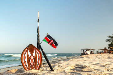 spear of Masai and the national flag of Kenya on the background of a beautiful beach landscape. the...