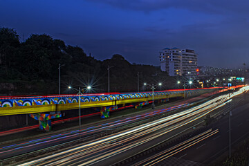 Slow shutter speed image of light trails, beautiful sunset sky , buildings and flowing traffic on...