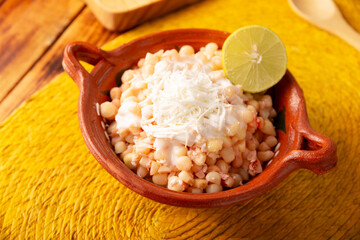 Esquites. Corn kernels cooked and served with mayo, sour cream, lemon and chili powder, very popular street food in Mexico, also known as Elote en Vaso. The recipe varies depending on the region. - 781800439