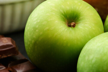 Closeup, healthy or apple for diet in kitchen of home on counter for diet, natural vitamin c or nutrition. Vegan, background or fruit with sweet chocolate in apartment or house for detox or minerals