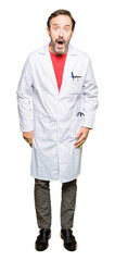 Fototapeta premium Middle age therapist wearing white coat afraid and shocked with surprise expression, fear and excited face.