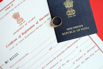 Indian Certificate of registration of marriage blank document and wedding ring with passport on table close up