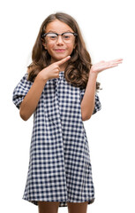 Brunette hispanic girl wearing glasses very happy pointing with hand and finger