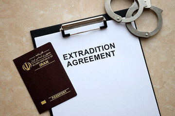 Passport of Iran and Extradition Agreement with handcuffs on table close up