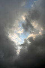 Fototapeta na wymiar Dunkle Wolken mit Loch zum Licht