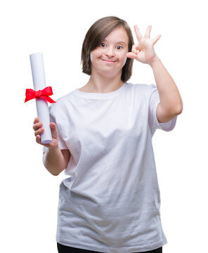 Young adult woman with down syndrome holding degree over isolated background doing ok sign with fingers, excellent symbol