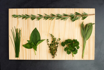 Parsley, thyme, and rosemary on chopping block for nutrition, health and adding flavour to food. Green herbs, basil and vegetables on kitchen cutting board for cooking, eating and vegan diet - obrazy, fototapety, plakaty