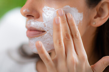 Self care moment as a woman applies a nourishing face mask in the comfort of her home - 781826035
