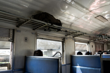 Empty passenger seats line the interior of a modern train car - 781829283