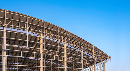 Part of large metal industrial factory building structure with corrugated steel curve roof and...