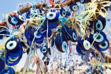 Close up on the many blue glass eyes hanging from the evil eye tree next to the Pigeon Valley, Güvercinlik Vadisi, close to Uchisar, Cappadocia, Turkey