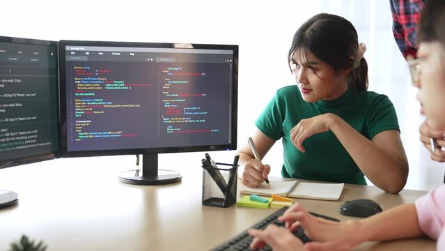Slow motion back end software developer engineer for computer programming working together on debugging writing computing code, solving complex algorithms display on monitor in office. Burgeoning