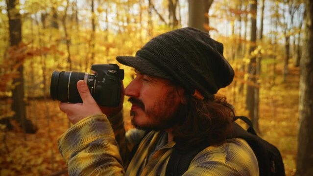 Photographer takes a photo in the forest during hike of the beautiful autumn colors.