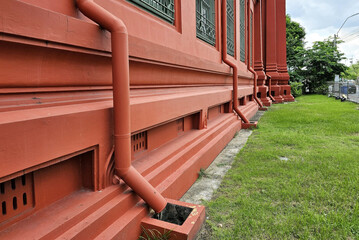 Red drain pipe at the red vintage building.
